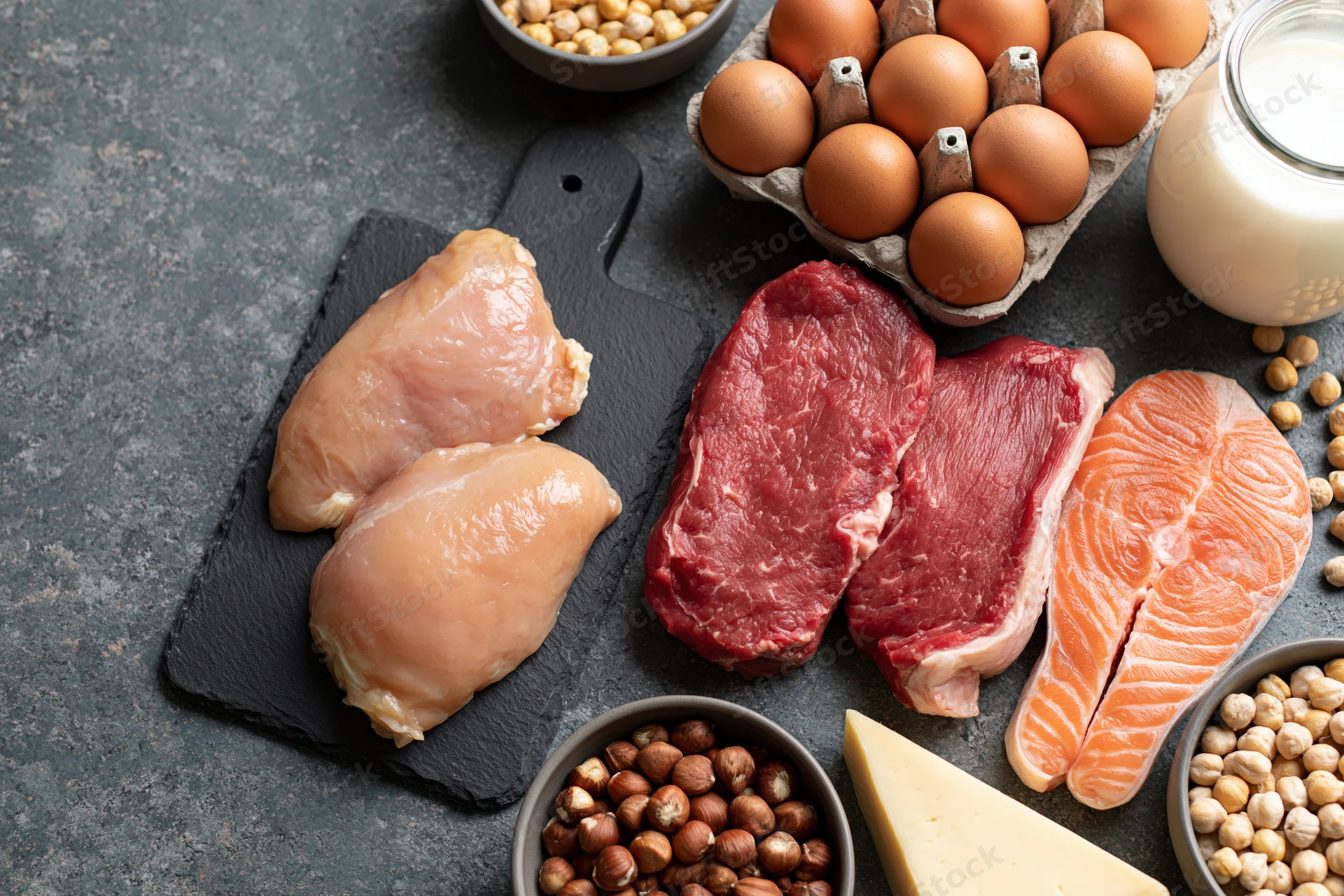 High-protein foods arranged in overhead flat lay on dark surface