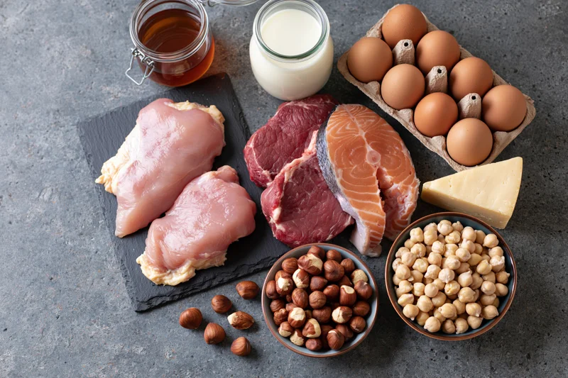 High-protein foods arranged in flat lay on dark stone countertop