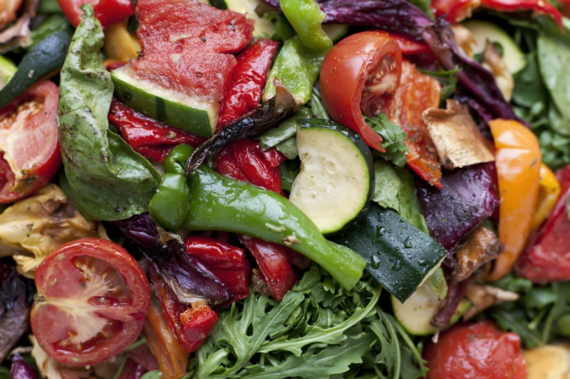 Closeup of roasted vegetables and greens mixed in a salad