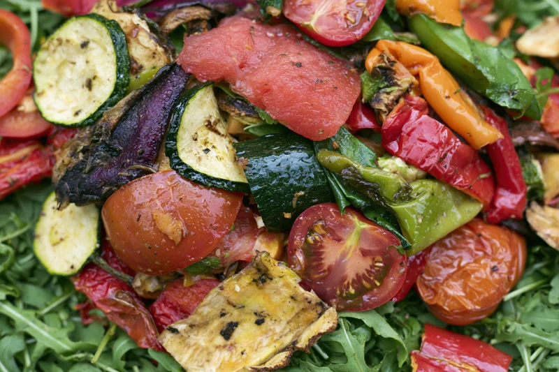 Grilled vegetables and watermelon on arugula salad