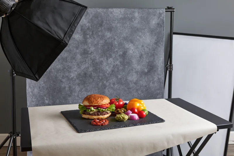Hamburger with fresh ingredients arranged on slate board in studio photography setup