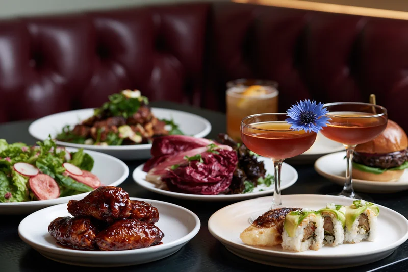 Restaurant table with multiple dishes and cocktails arranged for dining