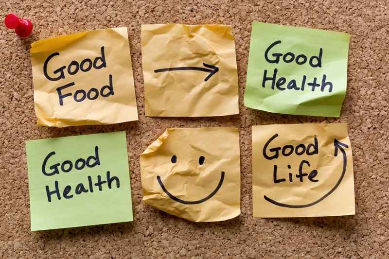 Crumpled sticky notes with handwritten messages arranged in grid on cork board