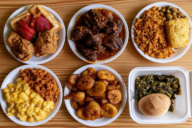 Six plates and one foam container with various soul food dishes arranged on a wooden table