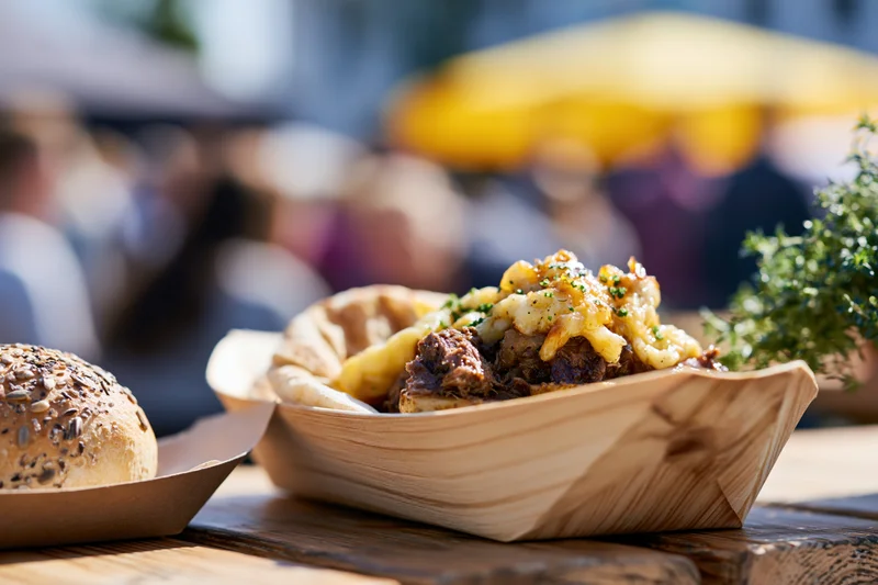 Street food served in a wooden boat tray on a table at an outdoor market