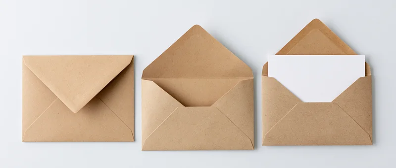 Three kraft paper envelopes arranged in a row, one closed, one open, one with a white paper insert, on a white background