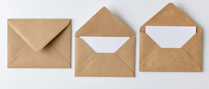 Three kraft paper envelopes arranged in a row, one closed and two open, on a white background