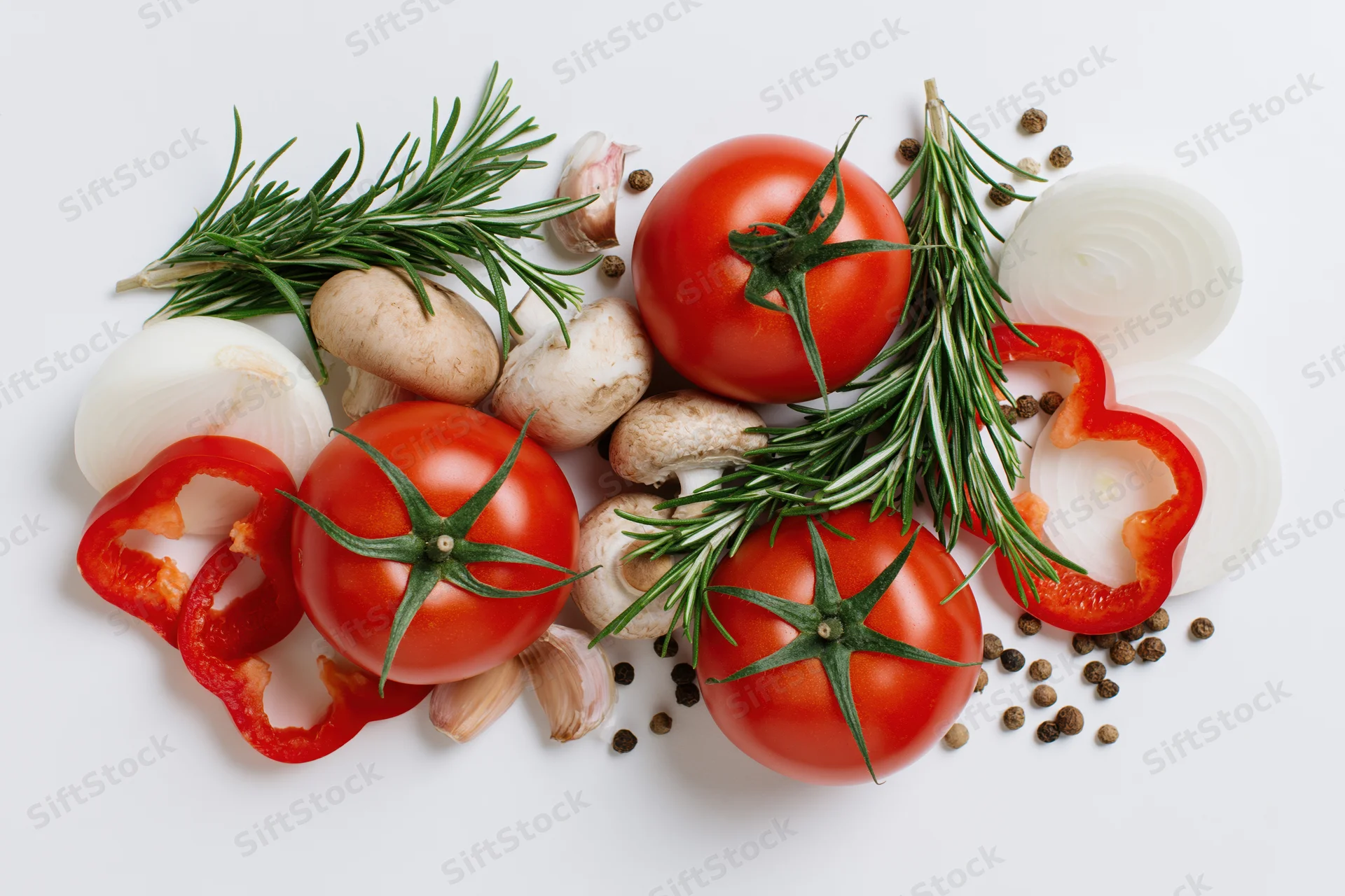 Ripe tomatoes with rosemary, garlic, onions, peppers and mushrooms arranged on white background