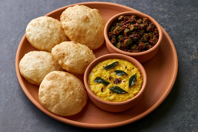 Traditional indian meal with samosas and dal served on a terracotta plate