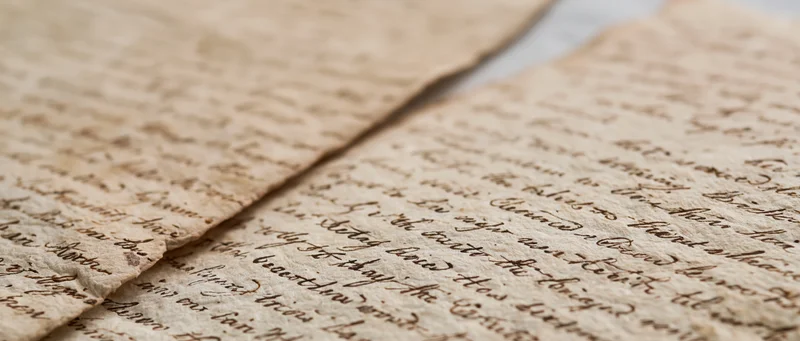 Two aged handwritten letters from the early 1800s overlapping on a textured surface