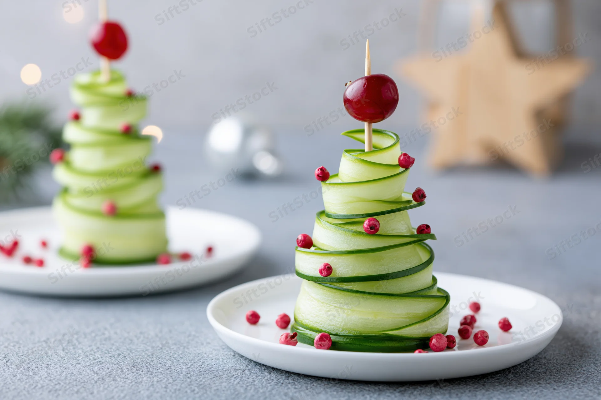 Cucumber ribbon christmas tree appetizers on white plates with red garnish
