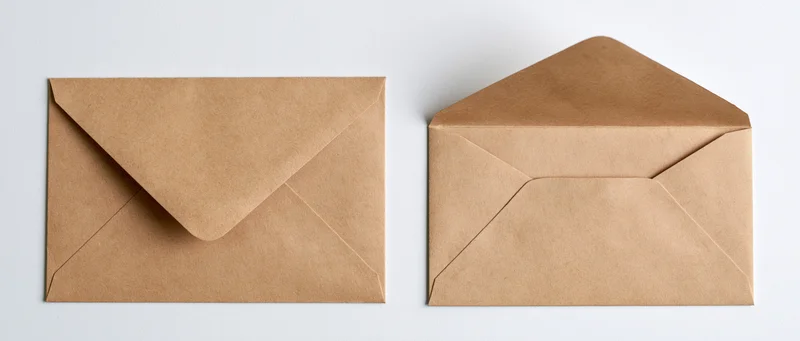 Two kraft paper envelopes side by side, one closed and one open, on a white background