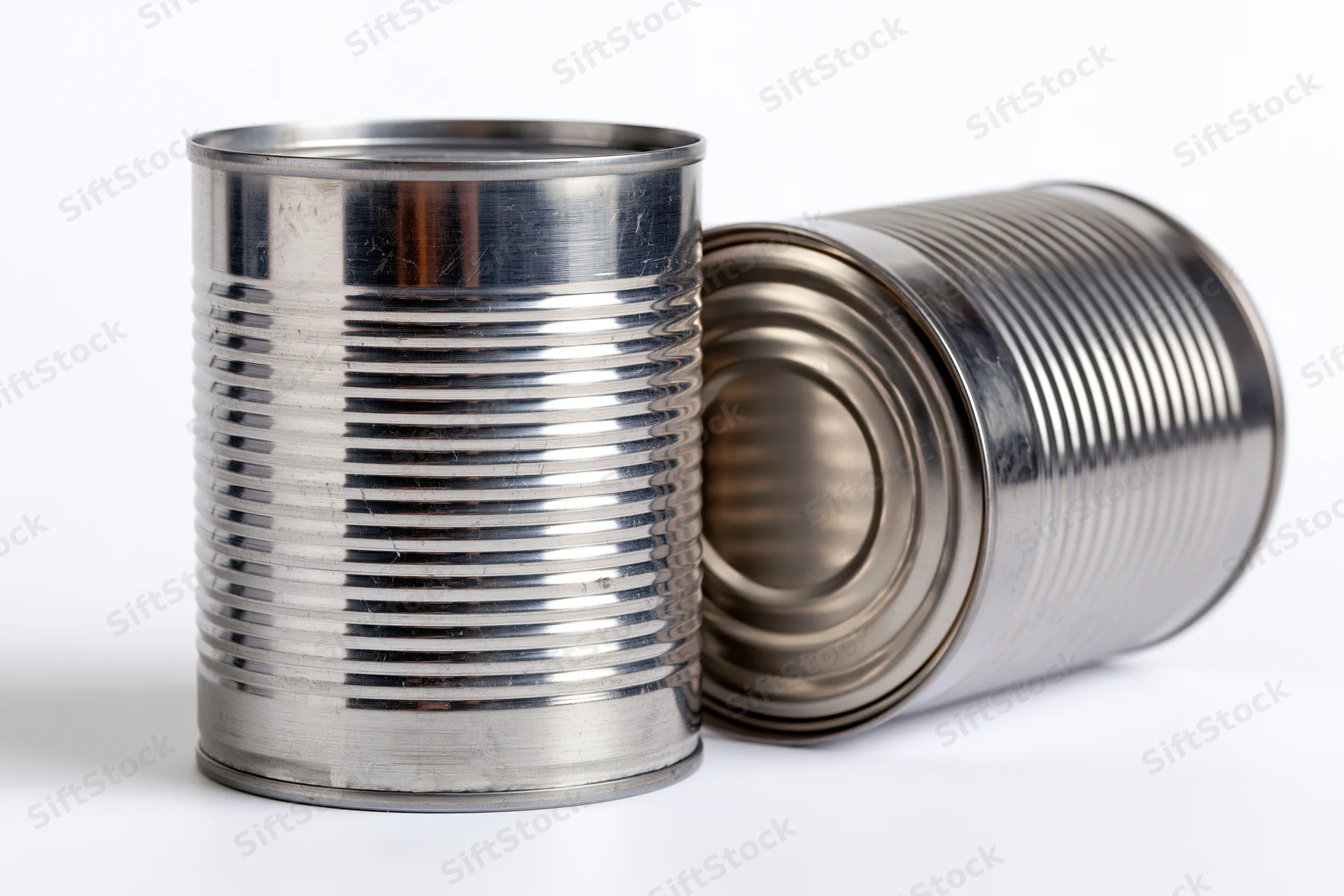 Two plain unlabeled steel tin cans arranged together on a white background