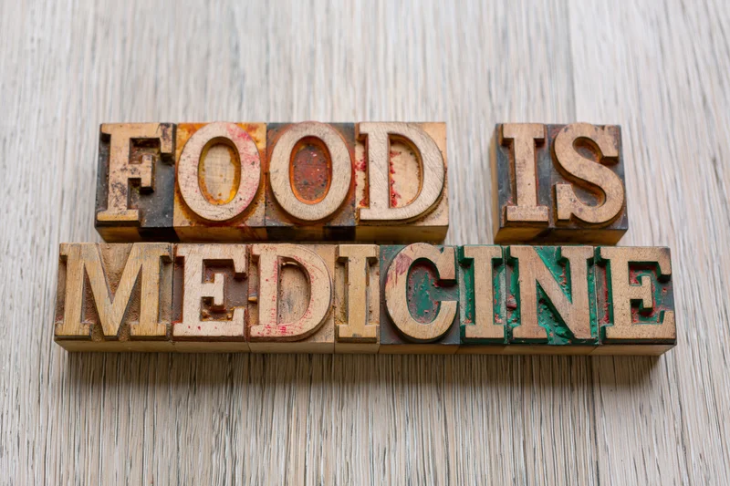 Wooden letterpress blocks spelling food is medicine on a textured surface