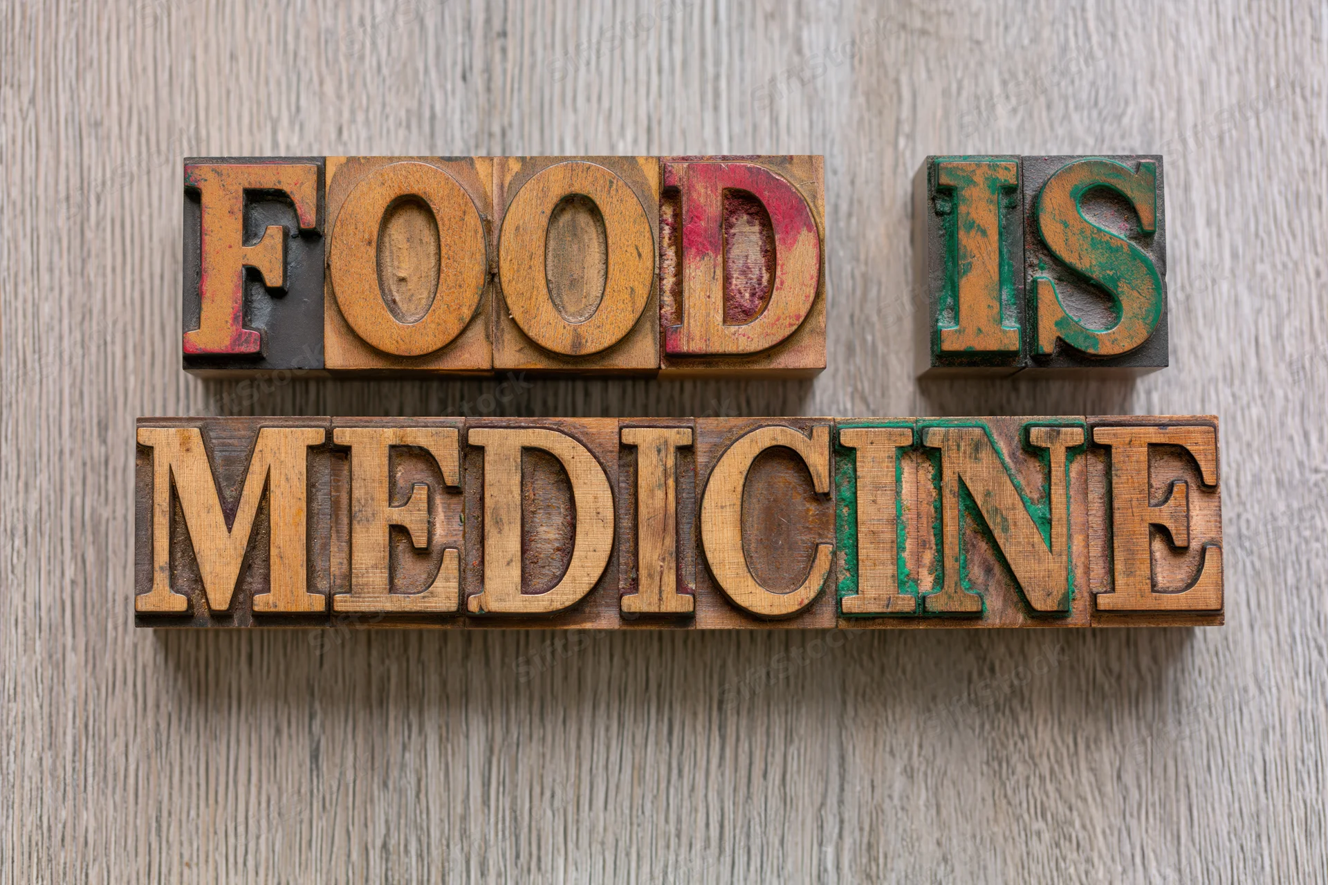 Vintage wooden letterpress blocks spelling food is medicine on a wooden surface