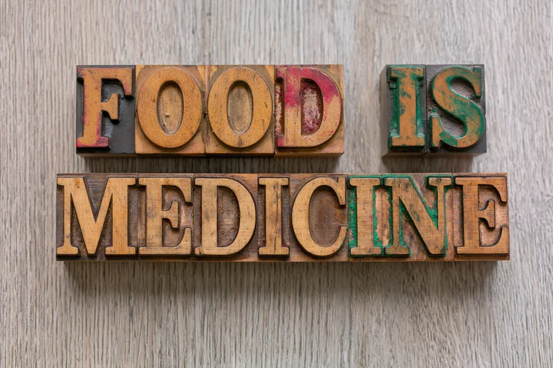 Vintage wooden letterpress blocks spelling food is medicine on a wooden surface