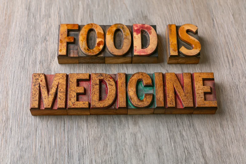 Wooden letterpress blocks spelling food is medicine on a textured surface