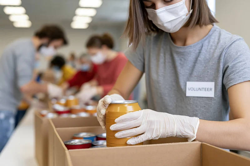 Volunteer placing canned food into a box at a donation center