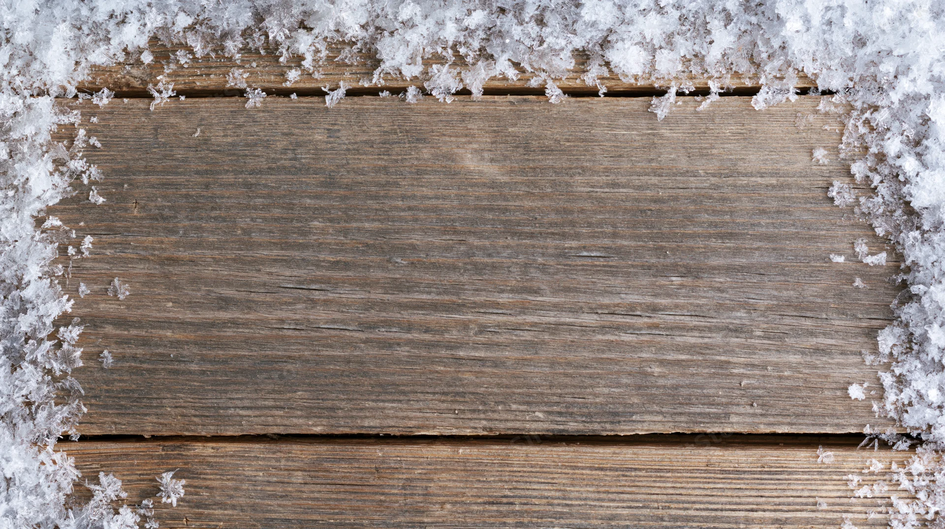 Snow-covered weathered wooden planks with central copyspace