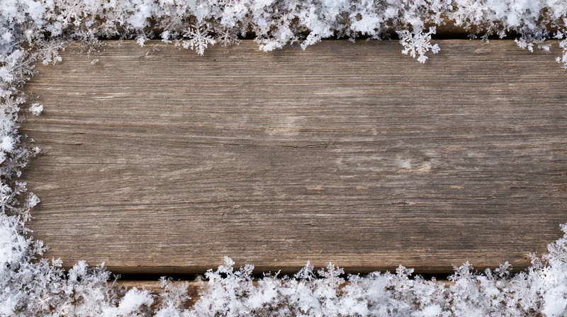 Weathered wooden plank surface bordered by snow and frost, top view with central copyspace