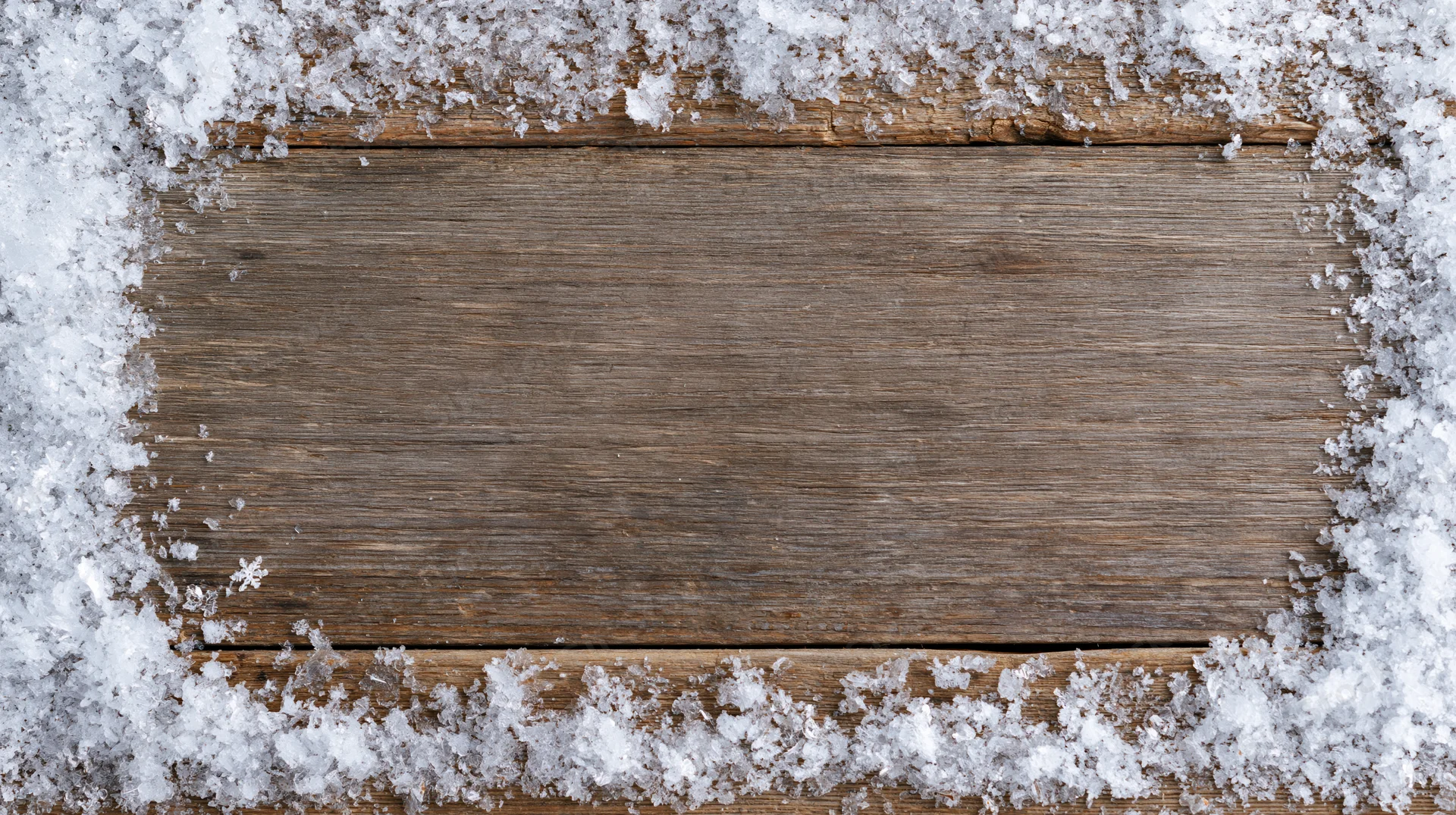 Snow-covered wooden plank surface with border frame, winter outdoor setting