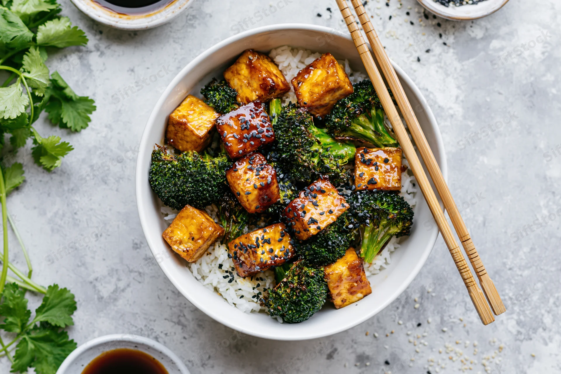 White ceramic bowl filled with teriyaki tofu cubes and broccoli