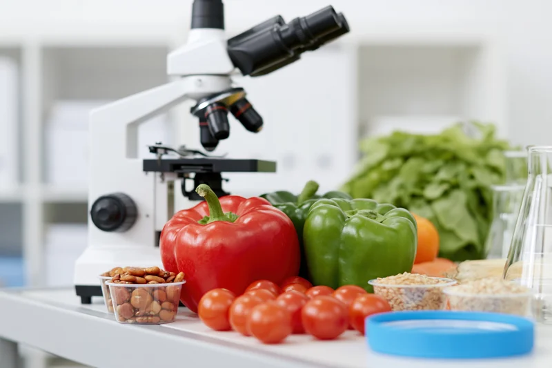 Microscope beside fresh vegetables on a lab table