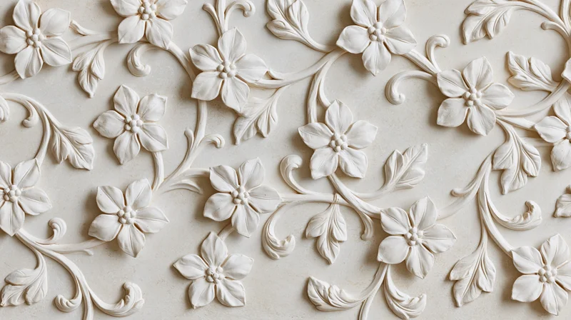 White plaster bas-relief panel with raised floral and leaf patterns covering the surface