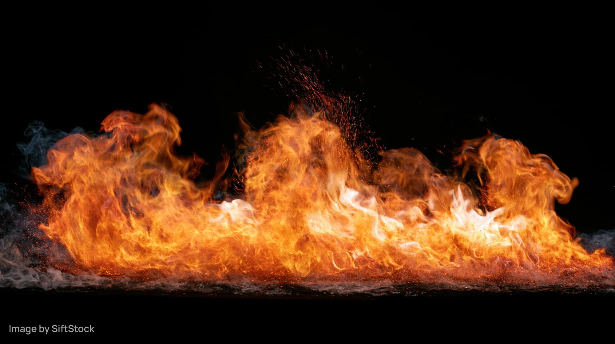 Horizontal band of fire burning intensely against a black background