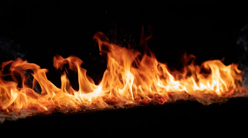 Horizontal band of fire burning against a black background