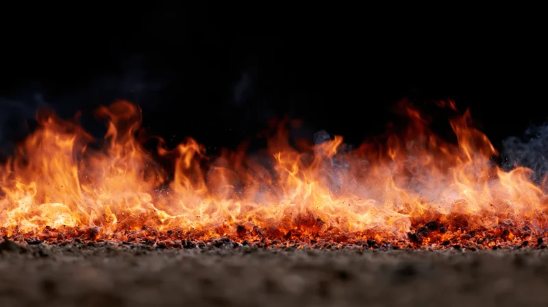 Low flames burning across a dark gravel surface at night
