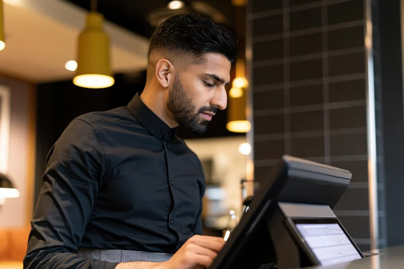 Man working at cash register in cafe interior