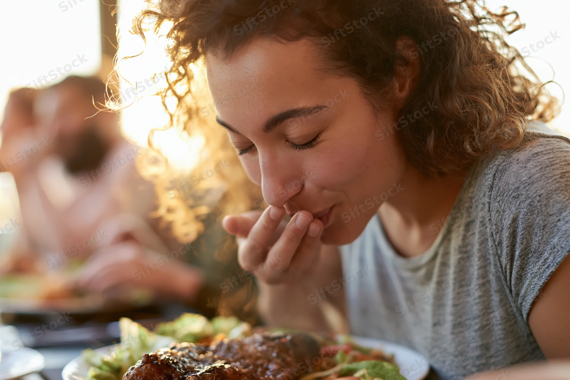 Woman eating grilled meat and salad at a restaurant table