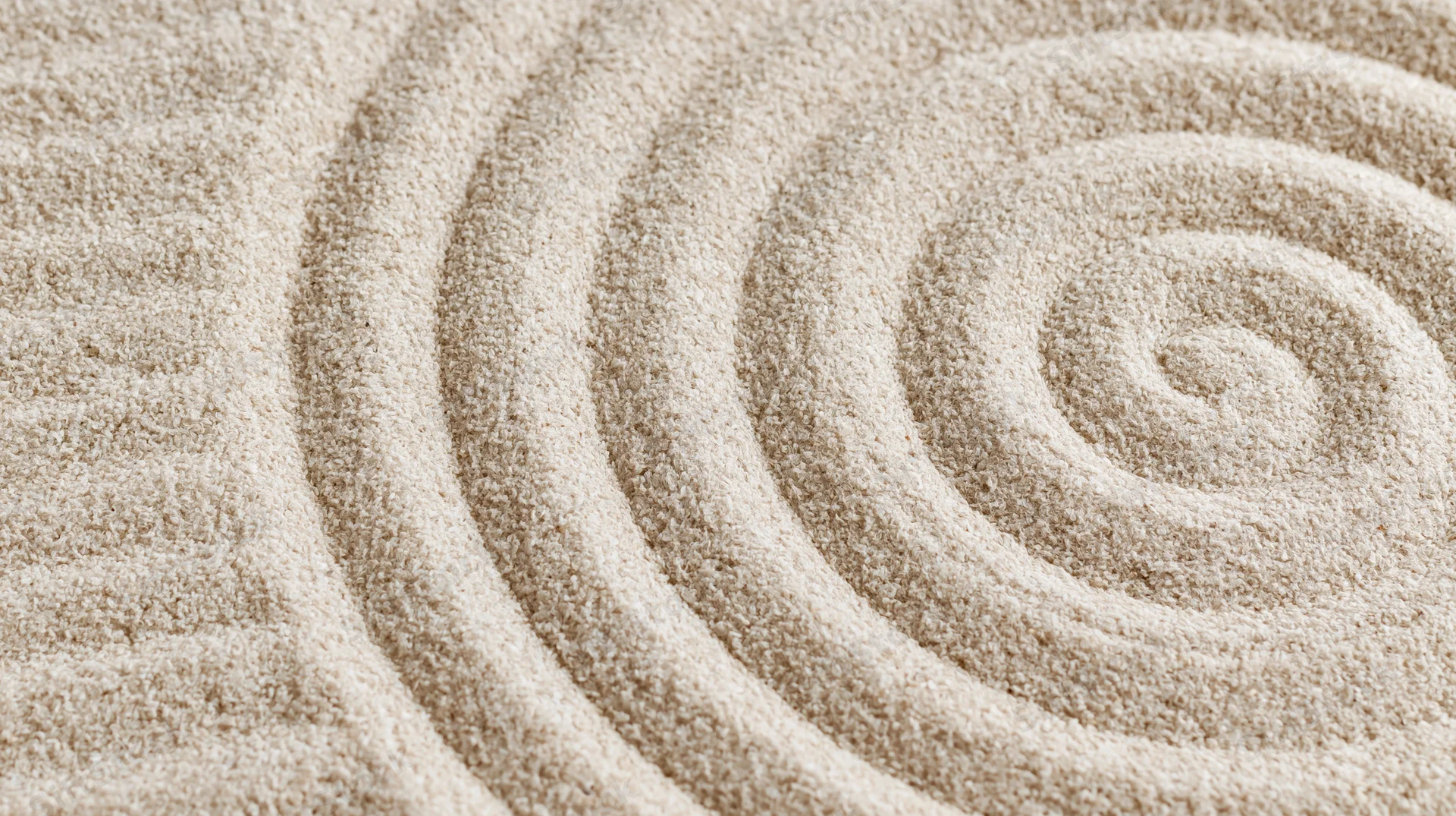 Raked sand forming a spiral pattern in a zen garden