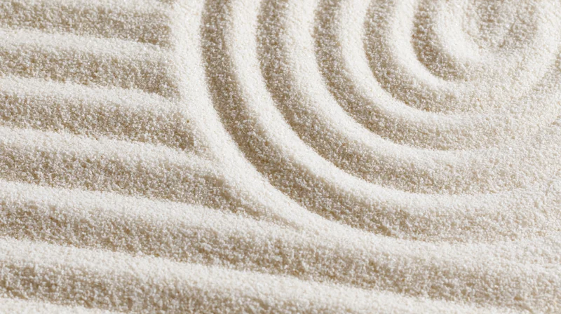 Raked sand in a zen garden forming parallel horizontal lines and a spiral pattern