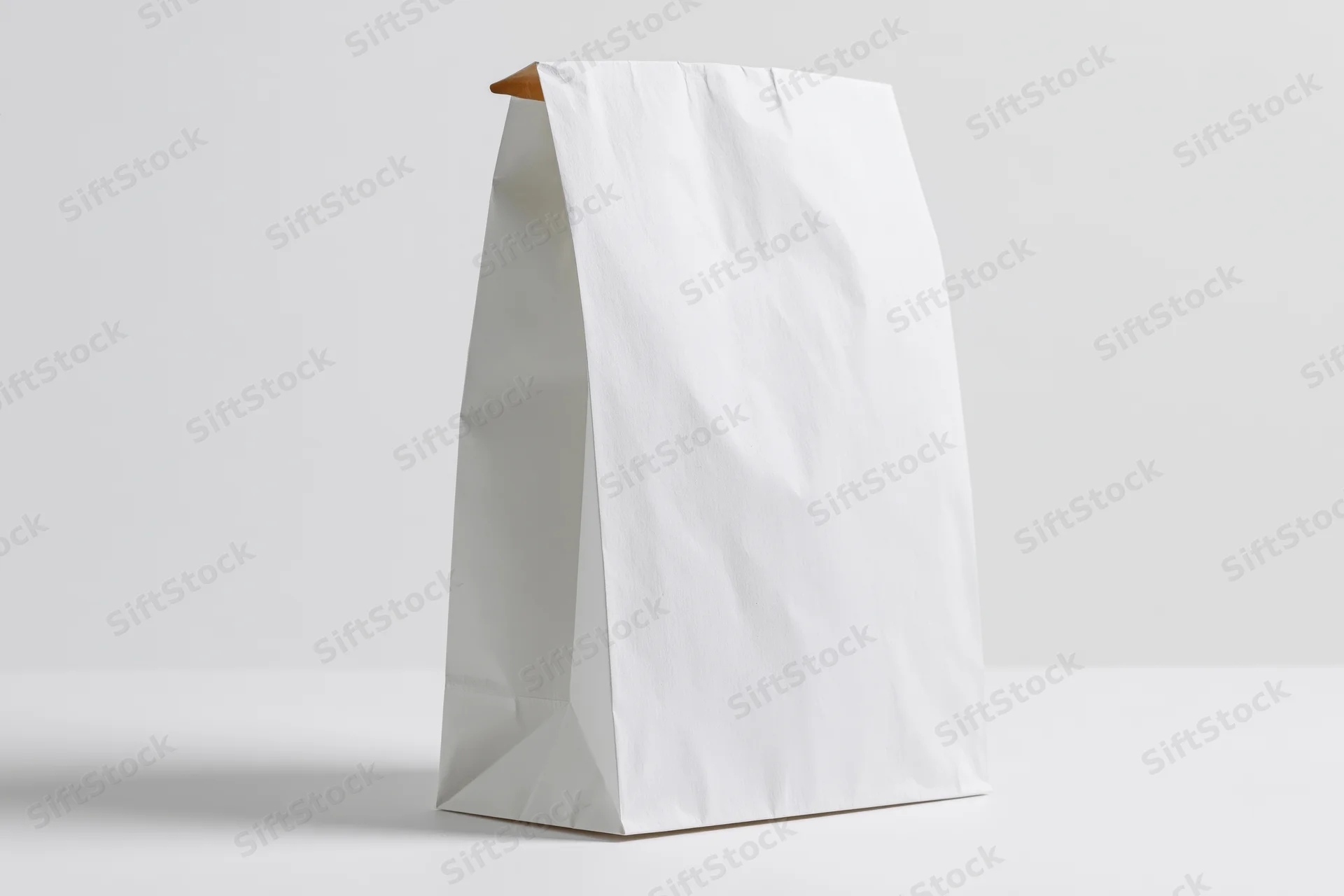 White paper bag standing upright on white surface as mockup for branding and packaging design