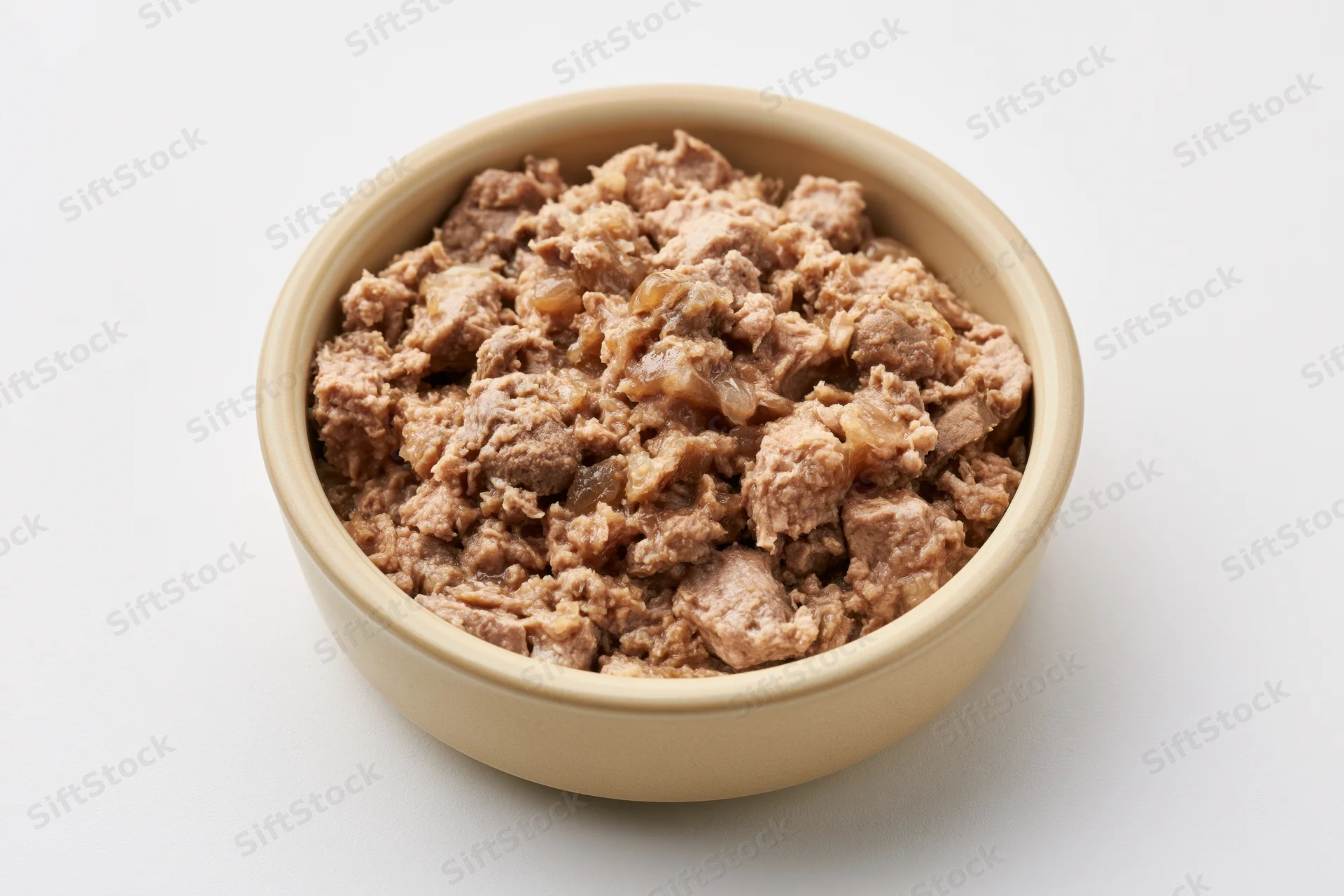 Chunky wet cat food in a small beige ceramic bowl on white background
