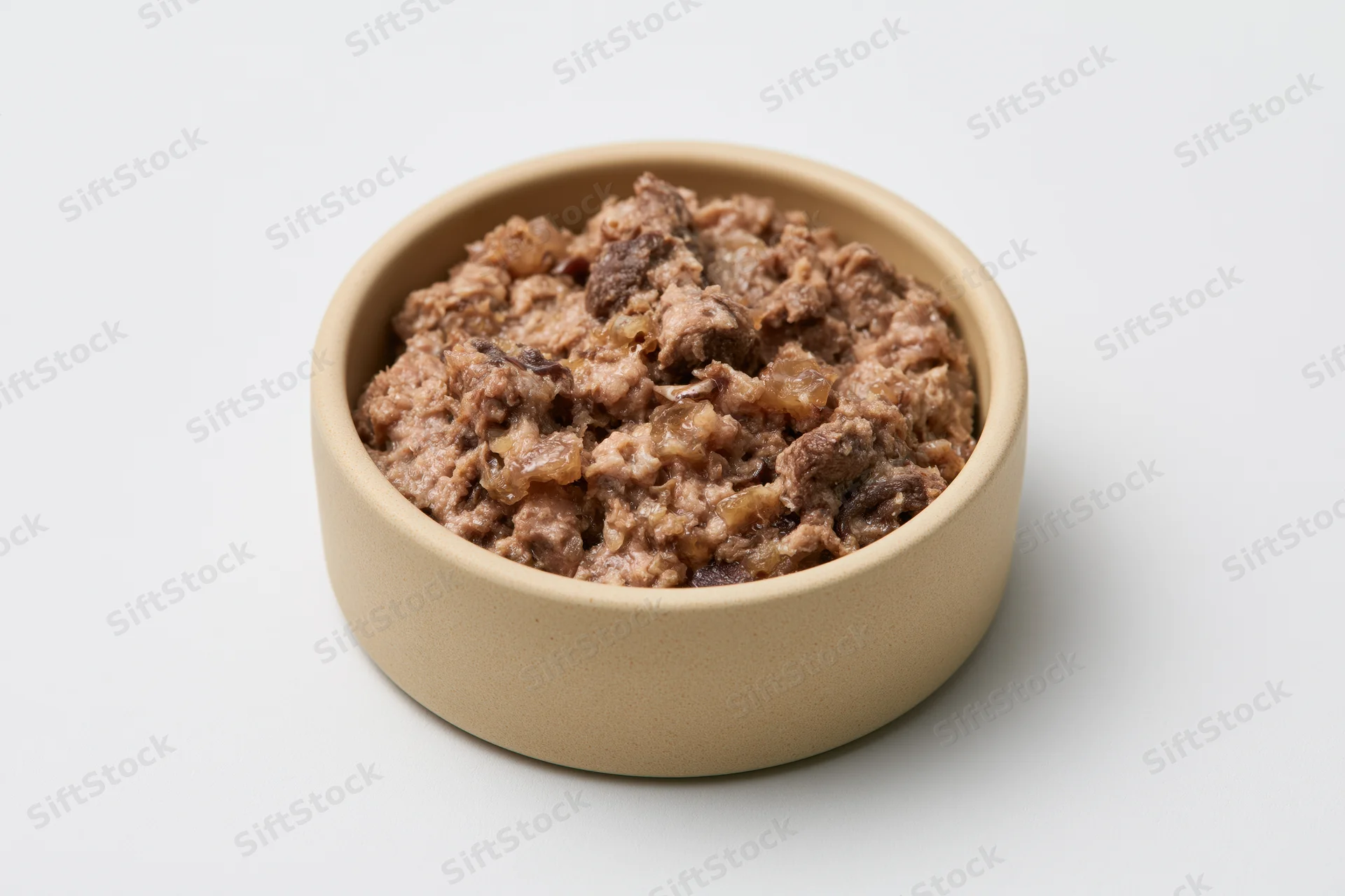 Chunky wet cat food in a small beige ceramic bowl on white background