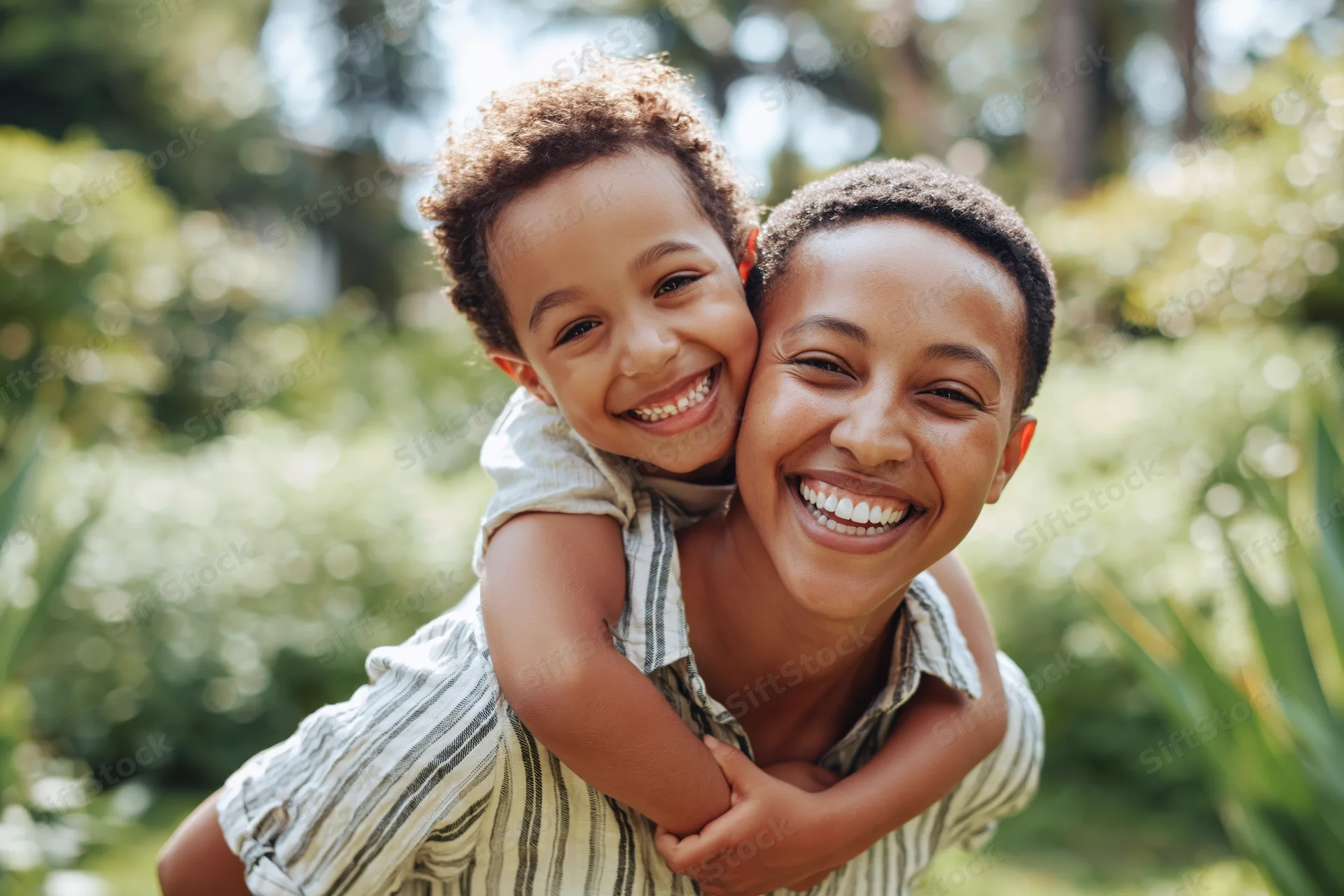 Woman carrying child on her back smiling in a lush garden
