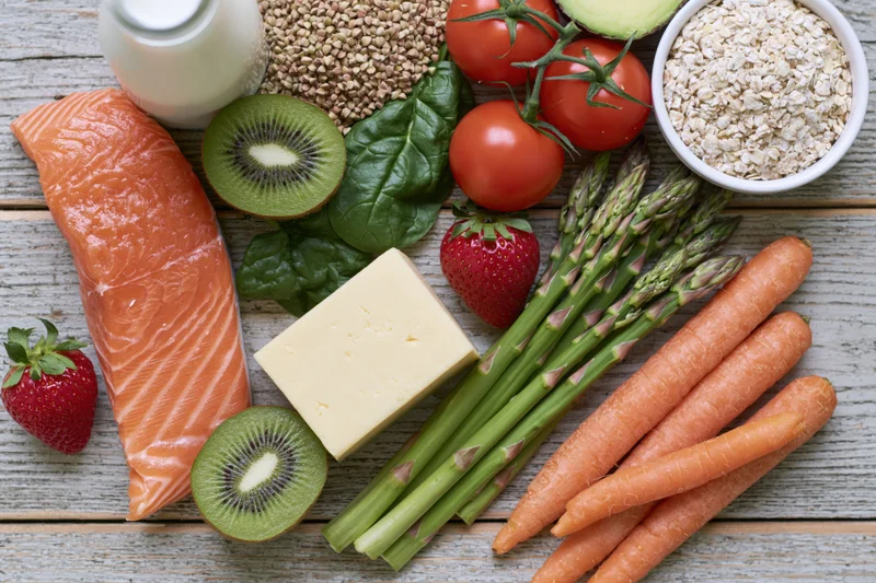 Assorted whole foods arranged in flat lay on wooden surface