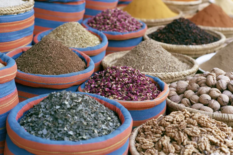 Colorful woven baskets filled with dried spices and nuts arranged in a market display