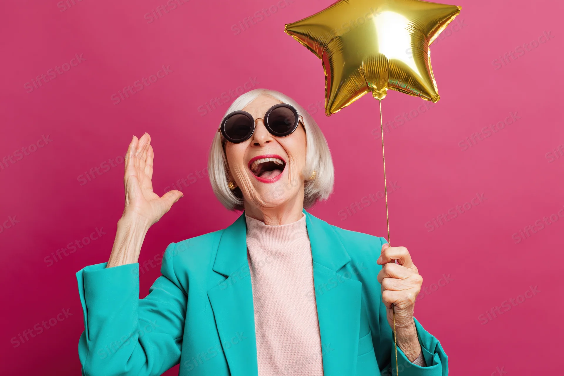 Elderly woman laughing widely while holding a gold star balloon against a pink background