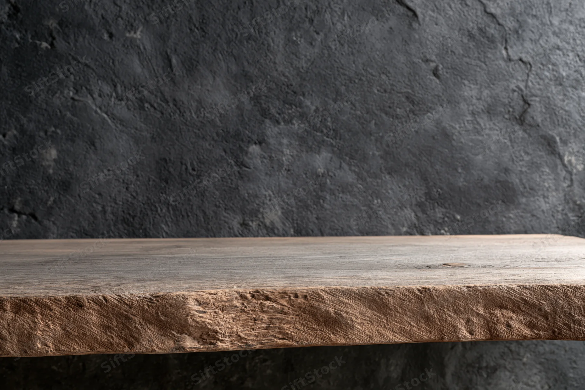Weathered wooden shelf against dark textured stone wall