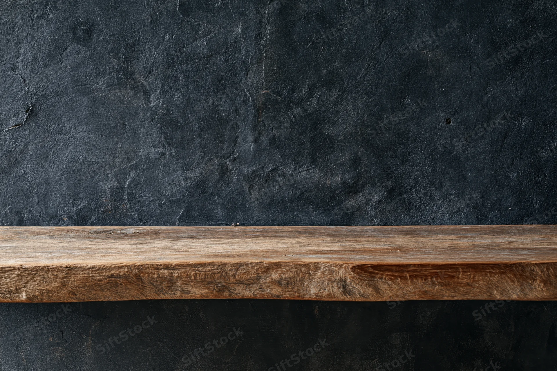 Weathered wooden shelf mounted against a dark textured wall