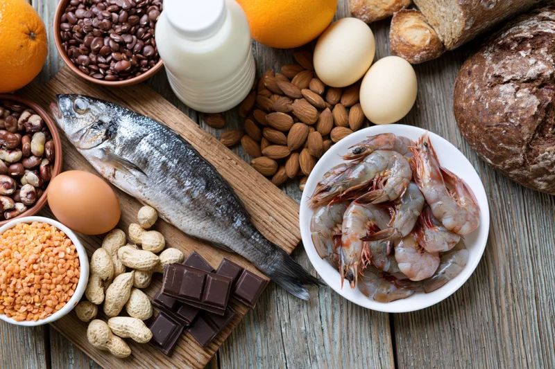 Various common food allergens arranged on a weathered wooden surface in a flat lay composition