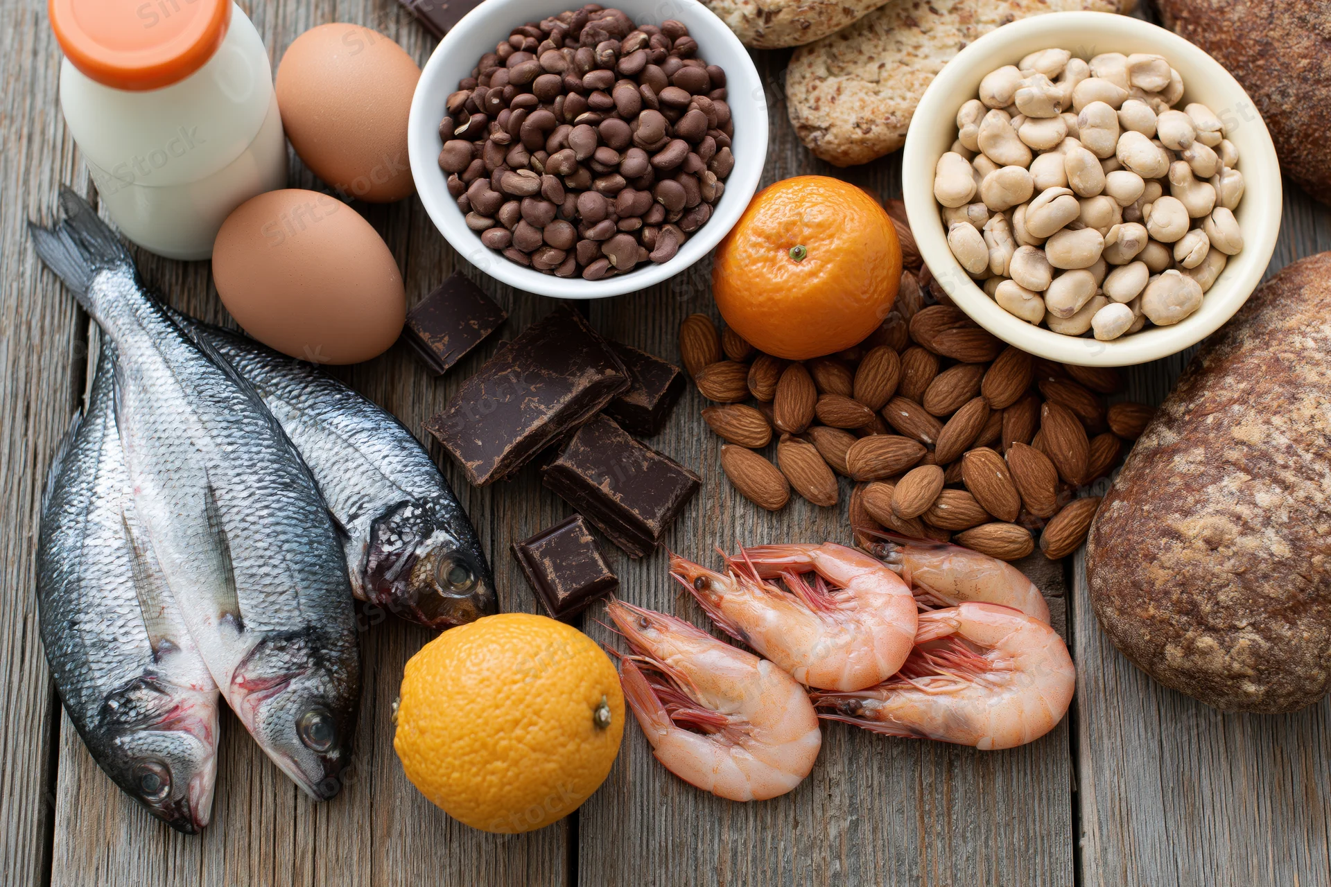 Various common food allergens arranged on a weathered wooden surface in a flat lay composition