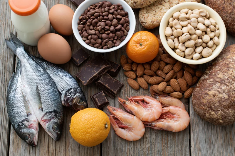Various common food allergens arranged on a weathered wooden surface in a flat lay composition
