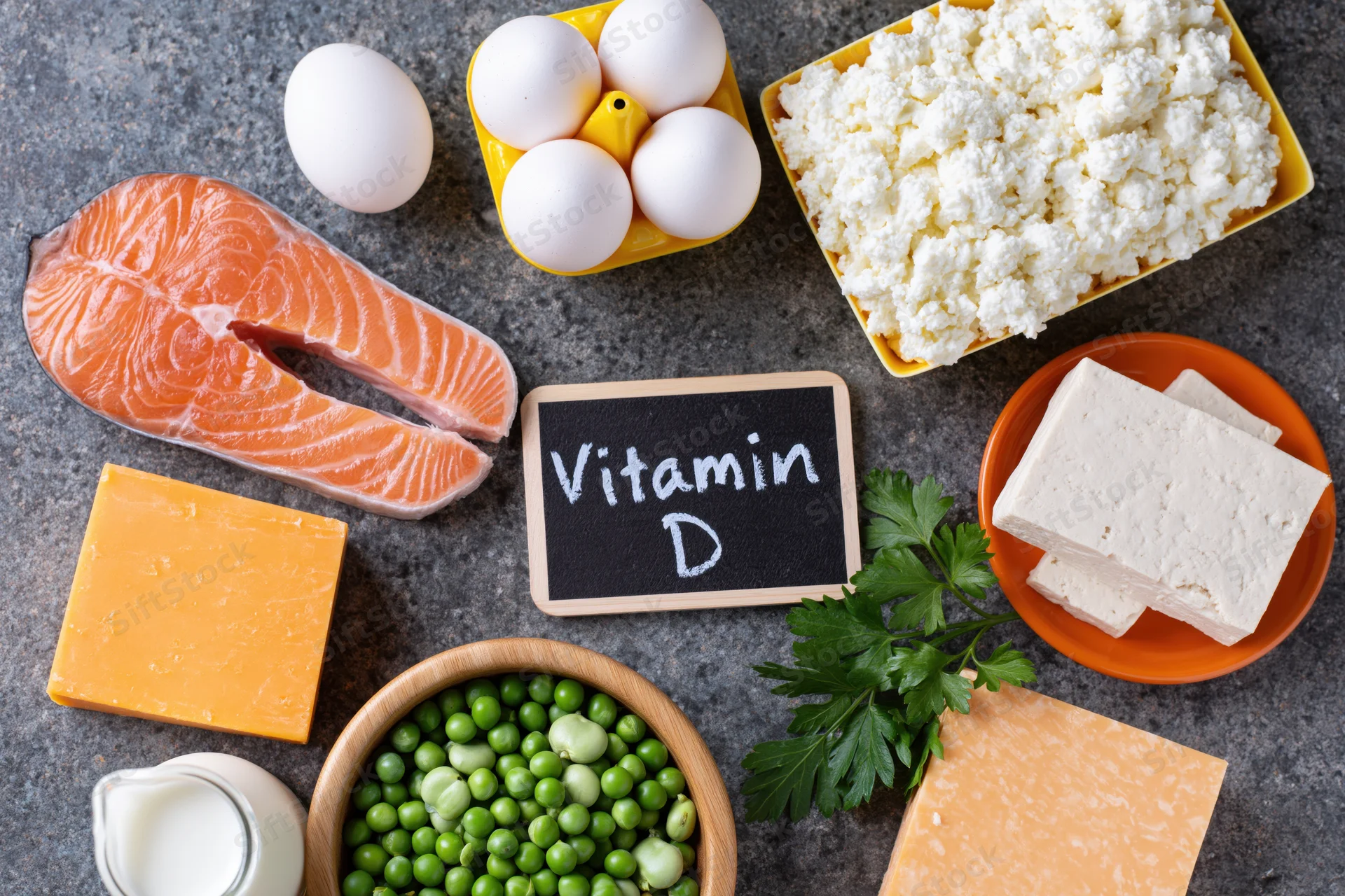 Vitamin d rich foods arranged on dark grey surface in flat lay composition