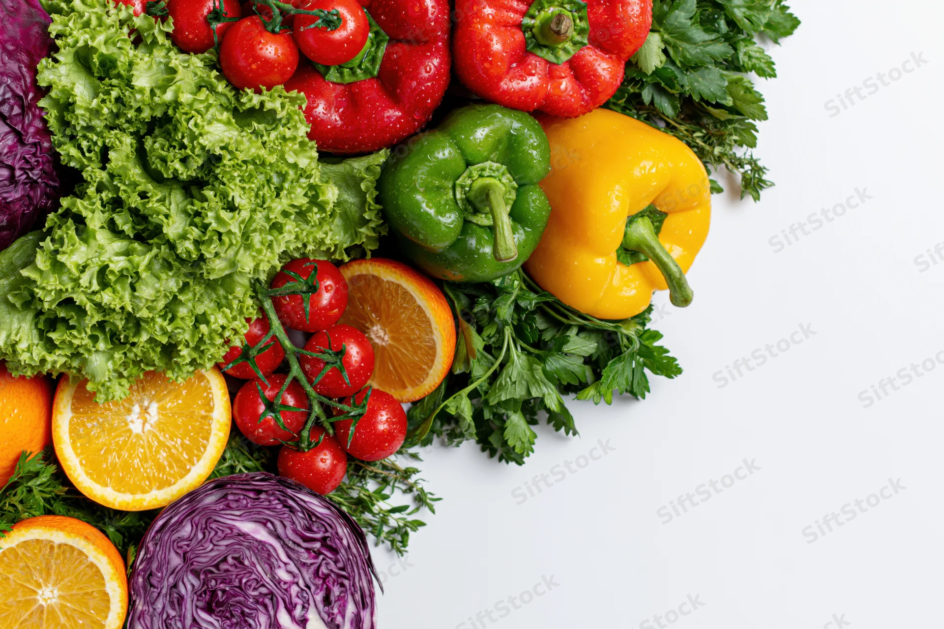 Fresh vegetables and fruits arranged along the left side on white background