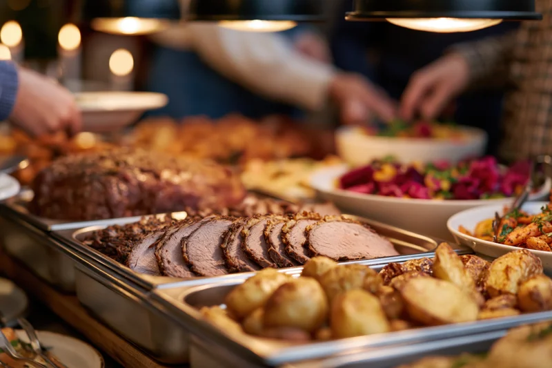 Holiday buffet spread with sliced roast meat and roasted potatoes on a serving table